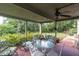 Relaxing covered patio area with a glass-top table, seating, and a ceiling fan at 9520 Indale Dr, New Port Richey, FL 34654