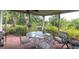Covered patio with an outdoor dining set and views of lush greenery at 9520 Indale Dr, New Port Richey, FL 34654