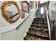 Classic staircase with ornate carpet, wood railing and painted walls with artwork at 9520 Indale Dr, New Port Richey, FL 34654