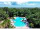 Aerial shot of the community pool featuring a unique clover shape and beautiful landscaping all around at 9567 Sandy Bluffs Cir, Parrish, FL 34219