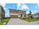Two-story home featuring a two-car garage, neutral siding, shuttered windows, and landscaped front yard at 9567 Sandy Bluffs Cir, Parrish, FL 34219