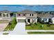 Two-story home featuring a two-car garage, neutral siding, shuttered windows, and landscaped front yard near a lake at 9567 Sandy Bluffs Cir, Parrish, FL 34219