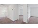 Bright hallway with carpet, neutral walls, and an open doorway create a welcoming transition between rooms at 9567 Sandy Bluffs Cir, Parrish, FL 34219