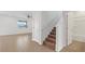 Neutral hallway with tile floors, white walls, and a carpeted staircase, alongside a full bathroom at 9567 Sandy Bluffs Cir, Parrish, FL 34219