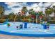 Outdoor splash pad area with colorful water features and palm trees under a blue sky at 9567 Sandy Bluffs Cir, Parrish, FL 34219