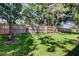 View of a backyard featuring a tall privacy fence and mature trees at 9814 Ashburn Lake Dr, Tampa, FL 33610