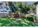 View of a spacious backyard with a wooden fence and mature trees offering plenty of shade at 9814 Ashburn Lake Dr, Tampa, FL 33610
