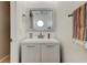 Compact powder room featuring a modern vanity, mirror, and a decorative hand towel at 9814 Ashburn Lake Dr, Tampa, FL 33610