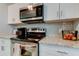 Bright kitchen featuring stainless steel appliances, granite countertops, and white cabinets at 9814 Ashburn Lake Dr, Tampa, FL 33610