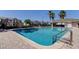 Relaxing community pool view; shimmering water and palm trees, seating, all under a clear blue sky at 9814 Ashburn Lake Dr, Tampa, FL 33610