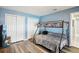 Bright bedroom featuring laminate floors, a bunkbed, and closet with blue walls at 10021 Elgin Blvd, Spring Hill, FL 34608
