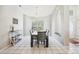 Bright dining area with a large window, stylish furniture, and white tile flooring at 10021 Elgin Blvd, Spring Hill, FL 34608