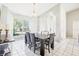 Bright dining area features a window, a modern chandelier, and seating for six people at 10021 Elgin Blvd, Spring Hill, FL 34608