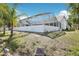 A view of the property featuring a screened-in pool and partial lawn on a sunny day at 10021 Elgin Blvd, Spring Hill, FL 34608