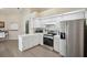 Efficient kitchen with stainless steel appliances, white cabinets, and wood-look flooring at 10021 Elgin Blvd, Spring Hill, FL 34608