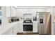 Well-lit kitchen with white cabinets, a stainless steel fridge, and wood-look floors at 10021 Elgin Blvd, Spring Hill, FL 34608