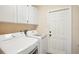 Practical laundry room with modern washer and dryer, and storage cabinets at 10021 Elgin Blvd, Spring Hill, FL 34608