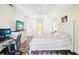 Bright main bedroom featuring stone tile floors, ceiling fan, and desk with light yellow walls at 10021 Elgin Blvd, Spring Hill, FL 34608