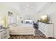 Bright main bedroom featuring stone tile floors, ceiling fan, and tv with light yellow walls at 10021 Elgin Blvd, Spring Hill, FL 34608