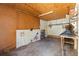 Inside of garage featuring open ceiling, wooden shelving, and outlets on the wall at 1205 E Emma St, Tampa, FL 33603