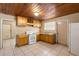 Functional kitchen features wood cabinets, white appliances, and tiled flooring at 1205 E Emma St, Tampa, FL 33603