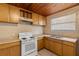 Functional kitchen features wood cabinets, white appliances, and tiled flooring at 1205 E Emma St, Tampa, FL 33603