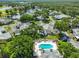 Aerial view of community featuring community pool, pond, and mature landscaping at 1211 Golfview Woods Dr, Sun City Center, FL 33573