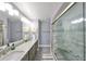 Modern bathroom featuring a double sink vanity with granite countertops and a glass-enclosed shower at 1211 Golfview Woods Dr, Sun City Center, FL 33573