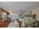 Bright bedroom with a decorative bed frame, shutters, ceiling fan, and hardwood floors at 1211 Golfview Woods Dr, Sun City Center, FL 33573