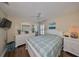 Bright bedroom featuring neutral walls, a ceiling fan, and a lovely window with white shutters at 1211 Golfview Woods Dr, Sun City Center, FL 33573