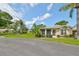 Well-maintained home exterior featuring a screened lanai and mature trees at 1211 Golfview Woods Dr, Sun City Center, FL 33573