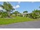 Beautifully landscaped front yard with lush green grass, mature trees, and well-maintained shrubs enhancing curb appeal at 1211 Golfview Woods Dr, Sun City Center, FL 33573