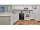 Bright kitchen featuring granite countertops, white cabinets, and modern appliances at 1211 Golfview Woods Dr, Sun City Center, FL 33573