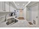 Well-lit kitchen features white cabinetry, stainless steel sink, and a convenient layout for cooking and dining at 1211 Golfview Woods Dr, Sun City Center, FL 33573