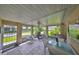 Enclosed patio featuring tile floors, ceiling fan, and comfortable wicker furniture with pleasant views of the outdoors at 1211 Golfview Woods Dr, Sun City Center, FL 33573