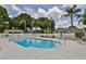 Inviting community swimming pool surrounded by a white fence and comfortable lounge chairs at 1211 Golfview Woods Dr, Sun City Center, FL 33573