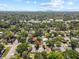 Aerial view of neighborhood with lush tree coverage and a cityscape in the distance on a sunny day at 1222 E Powhatan Ave, Tampa, FL 33604