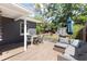 Exterior view of the back deck featuring outdoor seating, BBQ grill, and a spacious backyard at 1222 E Powhatan Ave, Tampa, FL 33604