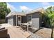 A gray home with a wooden deck features an outdoor table set and garden bed at 1222 E Powhatan Ave, Tampa, FL 33604