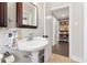Bathroom featuring a pedestal sink and a view into the hallway and a bookshelf at 1222 E Powhatan Ave, Tampa, FL 33604