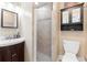 Bathroom with a tiled shower, a dark wood cabinet, and a white toilet and sink at 1222 E Powhatan Ave, Tampa, FL 33604
