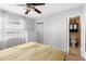 Bedroom with a ceiling fan, window, dresser and a view into the bathroom at 1222 E Powhatan Ave, Tampa, FL 33604