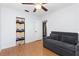 View of the light and airy bedroom with a gray couch and closet with colorful curtain at 1222 E Powhatan Ave, Tampa, FL 33604