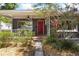 Inviting covered front porch with decorative railings and a vibrant red front door at 1222 E Powhatan Ave, Tampa, FL 33604