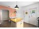 Kitchen featuring granite countertops, white cabinetry, an island and a view to an adjacent eating area at 1222 E Powhatan Ave, Tampa, FL 33604