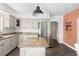 Kitchen with stainless steel appliances, granite counters, island, white cabinetry, and stylish pendant lighting at 1222 E Powhatan Ave, Tampa, FL 33604