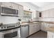 Charming kitchen featuring stainless steel appliances, granite countertops, and a window view of the outdoors at 1222 E Powhatan Ave, Tampa, FL 33604
