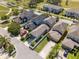 Aerial view of a neighborhood with houses featuring well-kept lawns, extended driveways, and tree-lined streets at 14493 Promenade Pkwy, Odessa, FL 33556
