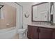 Bathroom featuring a granite vanity, decorative mirror, and a shower-tub combo at 14493 Promenade Pkwy, Odessa, FL 33556