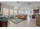Open concept living room with a large leather couch, modern rug, and ample natural light at 14493 Promenade Pkwy, Odessa, FL 33556